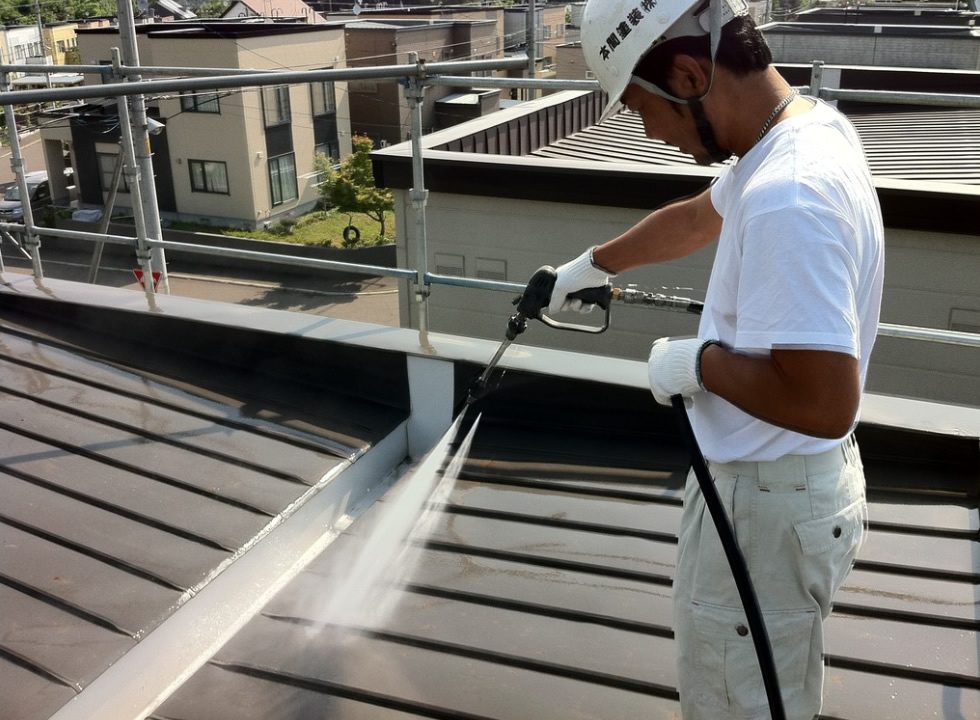 高圧洗浄で外壁の汚れを落としている職人